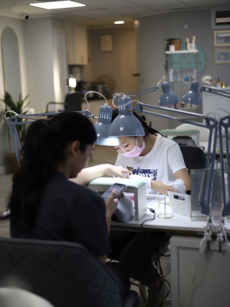 Technician performing a manicure at Nail Mania